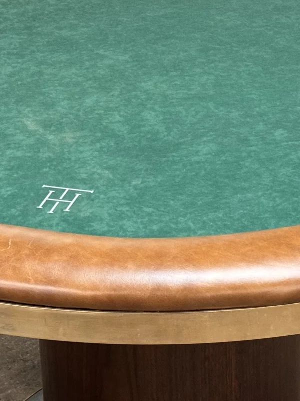 Close-up of the tan leather rail, distressed brass band and a customer's printed monogram